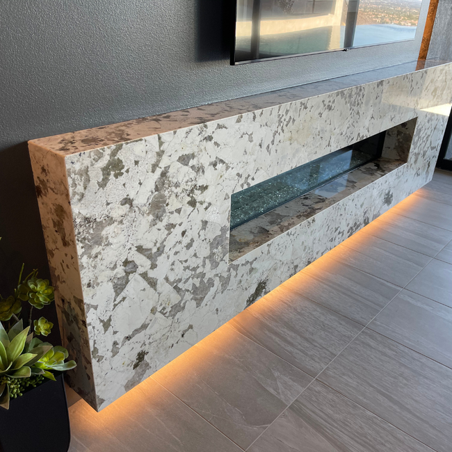Elegant custom stone fireplace with a sleek design and ambient lighting